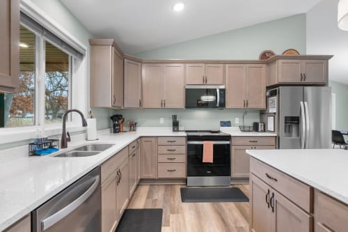 Your fully equipped kitchen features modern appliances, granite counters, and warm wood cabinetry—perfect for preparing memorable meals together.