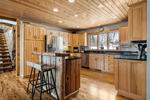 Your rustic kitchen blends modern convenience with cabin charm, featuring rich wood cabinetry and a welcoming island for memorable meal prep.