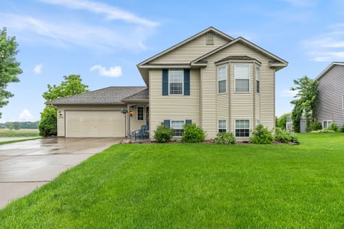 Spacious two-story home with attached garage, situated on well-maintained grounds in a quiet residential neighborhood.