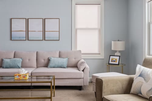 Sink into the plush sofa and unwind in this serene living space, where soft coastal blues meet modern comfort for your perfect getaway.