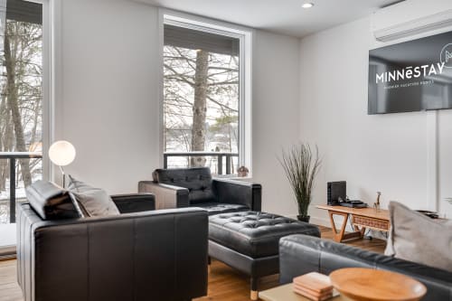 Sink into luxurious leather seating while winter views frame your stylish retreat through floor-to-ceiling windows.