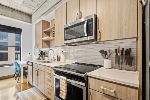 Your sleek modern kitchen features everything you need to cook at home, with stainless steel appliances and warm wood cabinets.