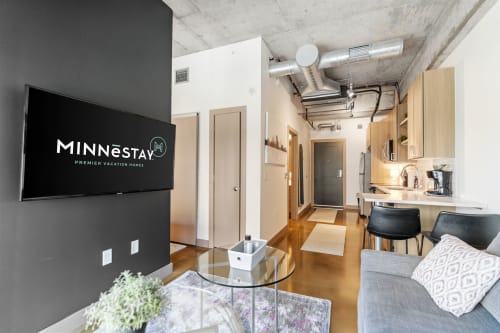 Step into your sleek urban retreat with exposed concrete ceilings, modern kitchen, and cozy living space perfect for city adventures.