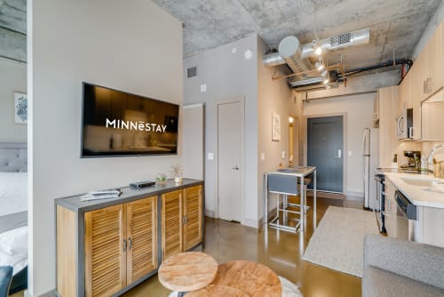 Your modern loft features exposed concrete ceilings, sleek kitchen, and entertainment center for urban living.