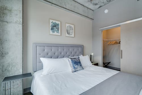 Sink into the plush tufted headboard and crisp linens of your stylish bedroom, where industrial charm meets modern comfort.