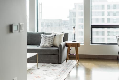 Unwind in your stylish living space with plush seating, modern touches, and sweeping city views through floor-to-ceiling windows.
