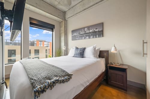 Rest peacefully in your stylish urban retreat with crisp linens and natural light flooding through expansive windows.