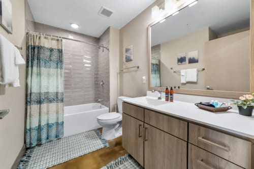 Unwind in your modern bathroom featuring a soaking tub, sleek vanity with ample counter space, and thoughtful touches like fresh flowers and premium amenities.