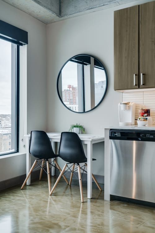 Your modern dining spot features sleek black chairs and city views, perfect for morning coffee or intimate meals together.
