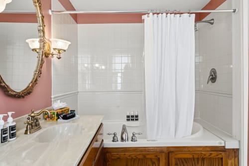 Step into your private bathroom featuring a luxurious soaking tub, refreshing shower, and charming vintage details that make every morning feel special.