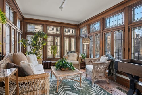 Relax in this sun-drenched 3 season conservatory where wicker chairs and lush greenery create your perfect morning coffee retreat.