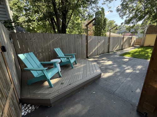 Relax on your private deck with turquoise Adirondack chairs, perfect for morning coffee or evening conversations in the peaceful backyard.