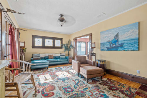 Relax in this charming living space with plush seating, vibrant artwork, and warm wood floors that create the perfect retreat.